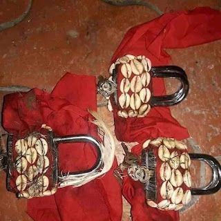 Cadenas ornés de cauris sur tissu rouge