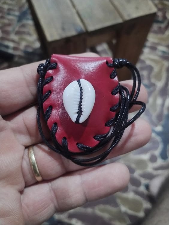 Talisman en cuir rouge orné d'un cauri